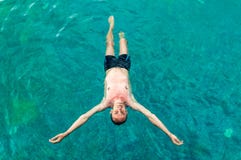 Top view of a young man floating in swimming pool with open arms royalty free stock photos Top view of a young man floating in swimming pool with open arms royalty free stock photos