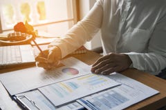 Top view of young working woman using laptop and reading report , graphs , charts, document at work. Business woman working at her stock image Top view of young working woman using laptop and reading report , graphs , charts, document at work. Business woman working at her stock image