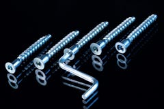 Tornillos potentes y llave para la reparación del equipo en un fondo negro fotografía de archivo Tornillos potentes y llave para la reparación del equipo en un fondo negro fotografía de archivo