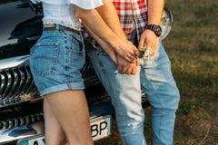torso of a man and a woman holding hands, with a flower and with a clock on his hand. standing near the car. stock image torso of a man and a woman holding hands, with a flower and with a clock on his hand. standing near the car. stock image