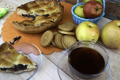 Torte, eine Scheibe des Apfelkuchens mit Kirsche und Walnüssen, eine Tasse Tee, Äpfel in einem Korb, Walnüsse und Plätzchen auf d lizenzfreies stockfoto Torte, eine Scheibe des Apfelkuchens mit Kirsche und Walnüssen, eine Tasse Tee, Äpfel in einem Korb, Walnüsse und Plätzchen auf d lizenzfreies stockfoto