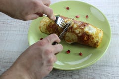 Tortilla del huevo frito del desayuno de la mañana rellena con el calabacín en la placa verde Cortarlo con un cuchillo y una bifu imagen de archivo Tortilla del huevo frito del desayuno de la mañana rellena con el calabacín en la placa verde Cortarlo con un cuchillo y una bifu imagen de archivo
