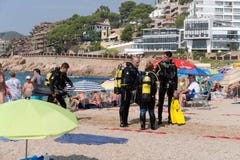 Tossa de Mar, Catalogna, Spagna, agosto 2018 Un gruppo di operatori subacquei che parlano sulla spiaggia nella stazione turistica fotografia stock Tossa de Mar, Catalogna, Spagna, agosto 2018 Un gruppo di operatori subacquei che parlano sulla spiaggia nella stazione turistica fotografia stock