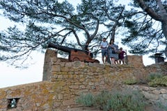 Tossa de Mar, España, agosto de 2018 Familia en la pared de una fortaleza medieval vieja cerca del cañón imagenes de archivo Tossa de Mar, España, agosto de 2018 Familia en la pared de una fortaleza medieval vieja cerca del cañón imagenes de archivo
