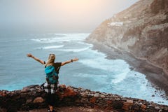 Tourist Girl Is Happy To Be On The End Of Long Trekking Route Leading Along Cliff Coastline With Ocean Waves From Royalty Free Stock Images