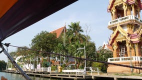 Tourist trip on Asian canal. View of calm channel and residential houses from decorated traditional Thai boat during stock video footage Tourist trip on Asian canal. View of calm channel and residential houses from decorated traditional Thai boat during stock video footage