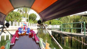 Tourist trip on Asian canal. View of calm channel and residential houses from decorated traditional Thai boat during stock video footage Tourist trip on Asian canal. View of calm channel and residential houses from decorated traditional Thai boat during stock video footage