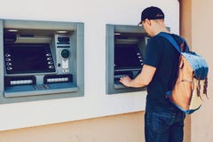 The tourist withdraws money from the ATM for further travel. Finance, credit card, withdrawal of money. Life style Stock Image The tourist withdraws money from the ATM for further travel. Finance, credit card, withdrawal of money. Life style Stock Image