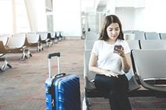 Tourist Women using Phone at international airport waiting for boarding stock photo Tourist Women using Phone at international airport waiting for boarding stock photo