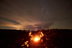 Touristenreisende, die durch brennendes Lagerfeuer auf Gebirgstal unter sternenklarem bewölktem Himmel sitzen stockbilder Touristenreisende, die durch brennendes Lagerfeuer auf Gebirgstal unter sternenklarem bewölktem Himmel sitzen stockbilder