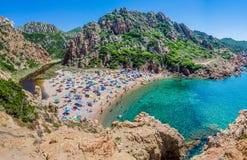 Tourists Colorful Sun Umbrellas At Costa Paradiso Beach, Sardinia, Italy Stock Photo