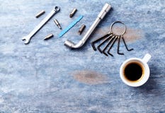 Tournevis, clés de sortilège, clé à douille, peu pour un tournevis et une tasse de café sur le fond en bois rustique images libres de droits Tournevis, clés de sortilège, clé à douille, peu pour un tournevis et une tasse de café sur le fond en bois rustique images libres de droits
