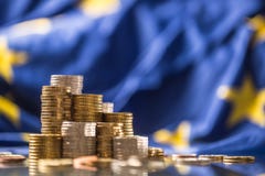 Tours avec d'euro pi?ces de monnaie et drapeau d'Union europ?enne ? l'arri?re-plan photographie stock libre de droits Tours avec d'euro pi?ces de monnaie et drapeau d'Union europ?enne ? l'arri?re-plan photographie stock libre de droits