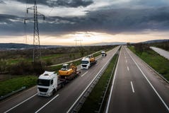 Tow Trucks em seguido que leva a construção faz à máquina máquinas escavadoras foto de stock Tow Trucks em seguido que leva a construção faz à máquina máquinas escavadoras foto de stock