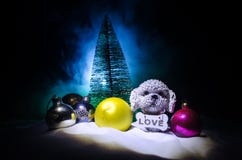 Toy dog - a symbol of the new year under the snow against the background of fir branches. Toy's dog as a symbol of 2018 New Year stock photo Toy dog - a symbol of the new year under the snow against the background of fir branches. Toy's dog as a symbol of 2018 New Year stock photo
