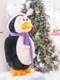 A toy penguin standing against Christmas trees surrounded with gift boxes. stock photography A toy penguin standing against Christmas trees surrounded with gift boxes. stock photography
