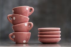Toy Porcelain Cups e placas cor-de-rosa pequenos com pontos brancos Fotografia de Stock Royalty Free Toy Porcelain Cups e placas cor-de-rosa pequenos com pontos brancos Fotografia de Stock Royalty Free