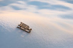 Sleigh on snow for greeting card. Wooden sleigh on white snow. Toy of sleigh on snow hill. Copy space. Greeting card for