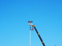 Trabajador de construcción usando auge de elevación en el cielo azul fotos de archivo Trabajador de construcción usando auge de elevación en el cielo azul fotos de archivo