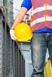 Trabajador en emplazamiento de la obra con el casco o el casco fotografía de archivo Trabajador en emplazamiento de la obra con el casco o el casco fotografía de archivo