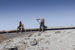 Trabajadores de construcción que cubren un granero fotografía de archivo Trabajadores de construcción que cubren un granero fotografía de archivo