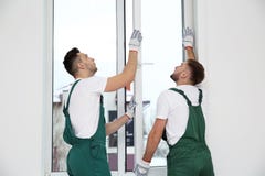 Trabajadores de construcción que instalan la ventana plástica foto de archivo Trabajadores de construcción que instalan la ventana plástica foto de archivo