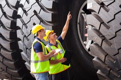 Trabajadores que comprueban los neumáticos Trabajadores que comprueban los neumáticos