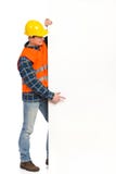 Trabalhador da construção que aponta na bandeira grande. Foto de Stock Trabalhador da construção que aponta na bandeira grande. Foto de Stock