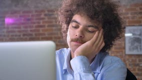 Trabalhador de escritório nerdy furado que datilografa no portátil e que senta-se no escritório moderno, tentando não dormir do e Trabalhador de escritório nerdy furado que datilografa no portátil e que senta-se no escritório moderno, tentando não dormir do e