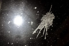 The trace of bird droppings on the windshield of the car at night, front and background blurred with bokeh effect stock photos The trace of bird droppings on the windshield of the car at night, front and background blurred with bokeh effect stock photos