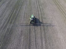 Tractor met scharnierend systeem om pesticiden te bespuiten Bevruchtend met een tractor, in de vorm van een aërosol, op het gebie stock afbeeldingen Tractor met scharnierend systeem om pesticiden te bespuiten Bevruchtend met een tractor, in de vorm van een aërosol, op het gebie stock afbeeldingen