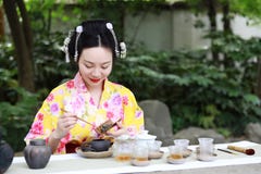 Traditional Asian Japanese Beautiful Geisha Woman Wears Kimono Show Tea Art Ceremony Drink Tea In A Summer Spring Outdorr Garden Stock Photos