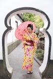 Traditional Asian Japanese Beautiful Woman Wears Kimono In A Spring Garden Park Stand By Bamboo Enjoy Free Time Fan Umbrella Royalty Free Stock Image