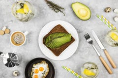 Traditional Breakfast - Toast From Rye Bread With Avocado, Fried Eggs From Quail Eggs, Lemonade On A Light Background. Top View Stock Photos Traditional Breakfast - Toast From Rye Bread With Avocado, Fried Eggs From Quail Eggs, Lemonade On A Light Background. Top View Stock Photos