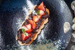 Traditional french eclairs served on premium dark plate. Food for breakfast with copy space. Top view profitroles classic. eclair royalty free stock images Traditional french eclairs served on premium dark plate. Food for breakfast with copy space. Top view profitroles classic. eclair royalty free stock images