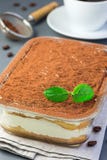 Traditional italian Tiramisu dessert cake in a glass form, decorated with cocoa powder, mint and coffee beans on a gray background royalty free stock photo Traditional italian Tiramisu dessert cake in a glass form, decorated with cocoa powder, mint and coffee beans on a gray background royalty free stock photo