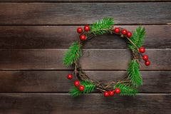 Traditionellt handgjort ris Holly Berries för filialer för träd för gran för julkransgräsplan på mörk plankaträbakgrund Top beskå Arkivfoton Traditionellt handgjort ris Holly Berries för filialer för träd för gran för julkransgräsplan på mörk plankaträbakgrund Top beskå Arkivfoton