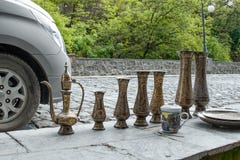 Tradycyjni Orientalni mosiężni handmade dzbanki z tradiitional ornamentem dla sprzedaży sprzedawcą ulicznym na pchli targ w Sheki fotografia royalty free Tradycyjni Orientalni mosiężni handmade dzbanki z tradiitional ornamentem dla sprzedaży sprzedawcą ulicznym na pchli targ w Sheki fotografia royalty free