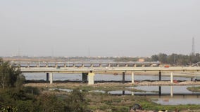 Trafic automobile sur le pont à hauteurs Signature sur la rivière Yamuna à Delhi, en arrière-plan de la ville banque de vidéos Trafic automobile sur le pont à hauteurs Signature sur la rivière Yamuna à Delhi, en arrière-plan de la ville banque de vidéos