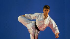 Tragender Kampfkunstkimono des Kerls, der seine Muskeln zu Beginn seines Routinetrainings ausdehnt stock video Tragender Kampfkunstkimono des Kerls, der seine Muskeln zu Beginn seines Routinetrainings ausdehnt stock video