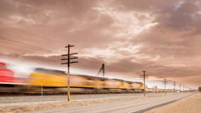 Train moves on tracks along a road with motion blurr stock photo Train moves on tracks along a road with motion blurr stock photo