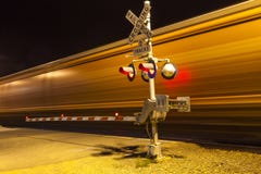 Train Passing A Railway Crossing By Night Royalty Free Stock Images