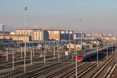 Train on railways with typical buildings and muontains on background. Lingotto district. Turin. Italy.