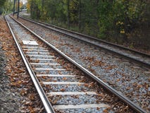Tramwaju ślad w mieście wśród drzew, jesień liście zdjęcie stock Tramwaju ślad w mieście wśród drzew, jesień liście zdjęcie stock