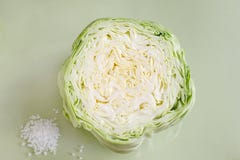 Tranche de chou blanc et sel brut de mer sur le fond vert clair photographie stock Tranche de chou blanc et sel brut de mer sur le fond vert clair photographie stock
