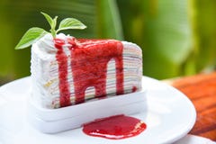 Tranche de gâteau de crêpe avec de la sauce à fraise sur le fond blanc de vert de plat et de nature - morceau d'arcs-en-ciel de g photo stock Tranche de gâteau de crêpe avec de la sauce à fraise sur le fond blanc de vert de plat et de nature - morceau d'arcs-en-ciel de g photo stock
