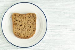 Tranche de pain de grain avec le moule D'un plat blanc avec une rayure bleue Sur une table en bois image stock Tranche de pain de grain avec le moule D'un plat blanc avec une rayure bleue Sur une table en bois image stock