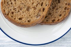 Tranches de pain de grain avec le moule D'un plat blanc avec une rayure bleue Sur une table en bois photos libres de droits Tranches de pain de grain avec le moule D'un plat blanc avec une rayure bleue Sur une table en bois photos libres de droits
