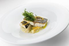 Tranches de plat de poisson de filets de bar de mer sur les légumes écrasés photos stock Tranches de plat de poisson de filets de bar de mer sur les légumes écrasés photos stock