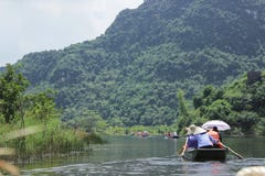 Trang, Ninh Binh Wietnam, Wrzesie?, - 13,2014: Go?cie odwiedzaj? pi?kn? rzek? i g?r? od ?odzi wzd?u? rzeki obrazy stock Trang, Ninh Binh Wietnam, Wrzesie?, - 13,2014: Go?cie odwiedzaj? pi?kn? rzek? i g?r? od ?odzi wzd?u? rzeki obrazy stock